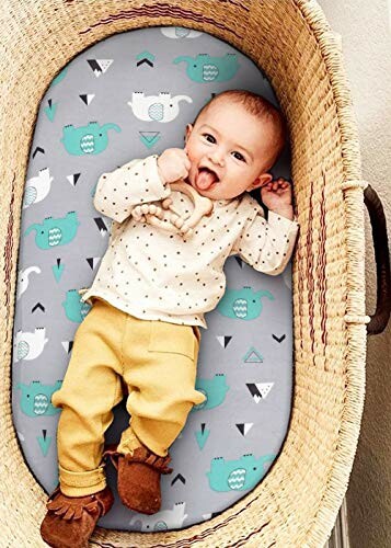 Baby lying in a basket on a patterned cushion