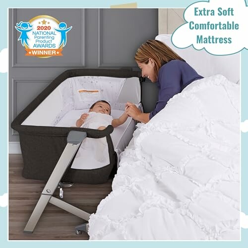 Mother lying in bed holding hand of baby in a bassinet with award badge for extra soft mattress.