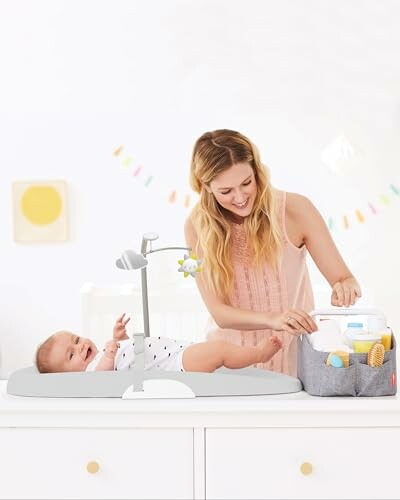 Mother changing baby's diaper on a changing table with organizer.