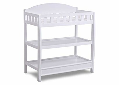 White wooden baby changing table with shelves.