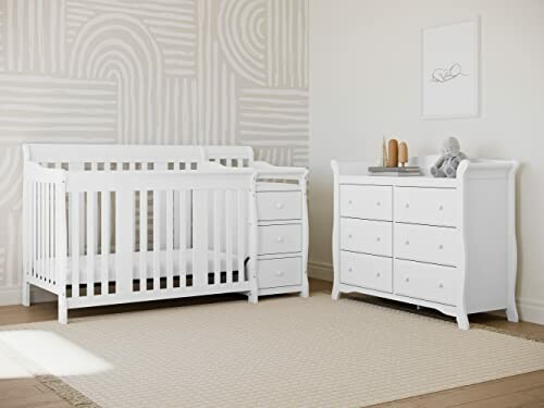 White baby crib and dresser in a nursery.